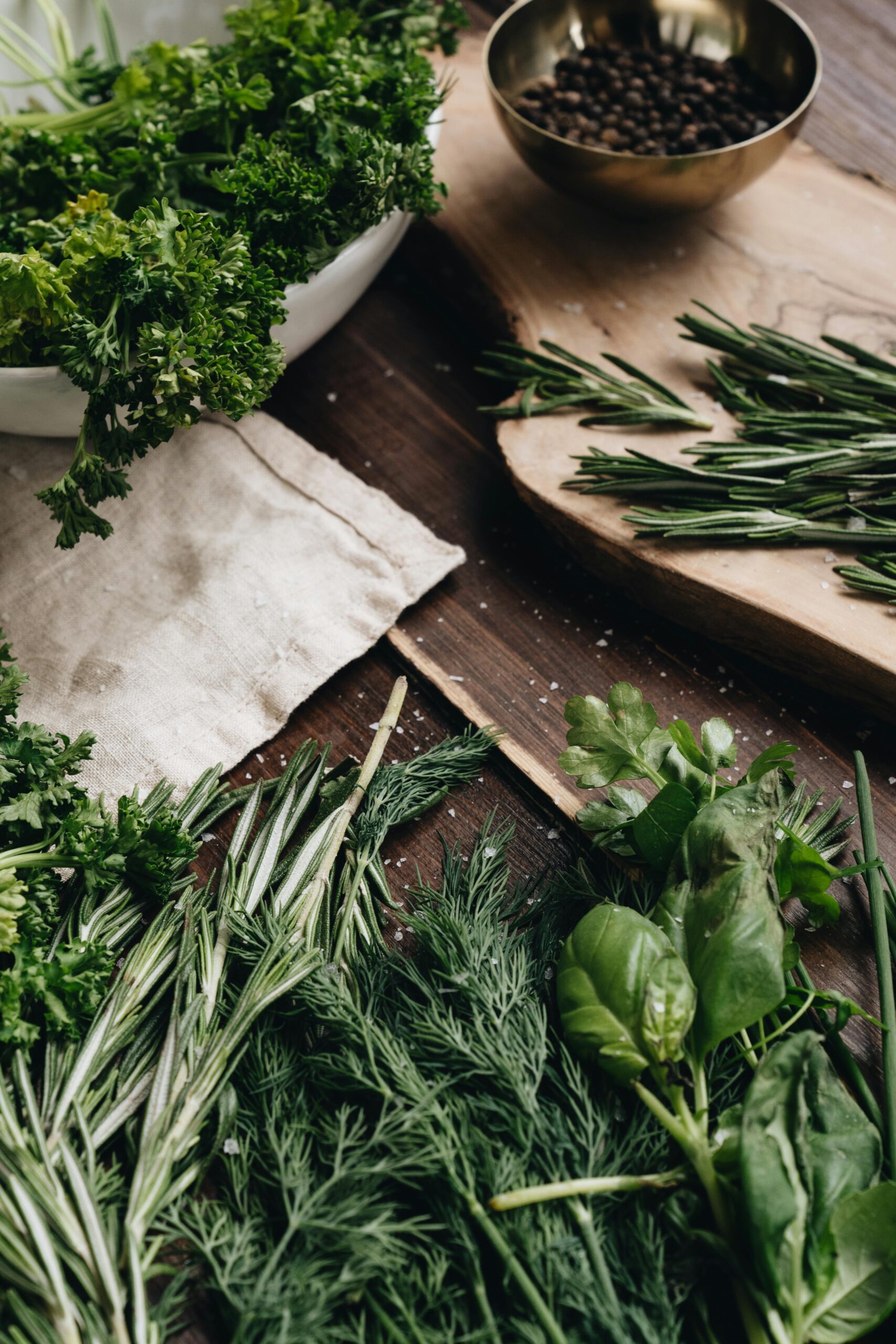 pexels-photo-4113927-4113927 A variety of fresh herbs including rosemary, dill, and basil arranged on a wooden board for culinary use.