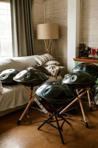 A collection of handpans arranged in a cozy living room setting, showcasing musical art.